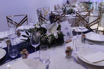 Assiette de crevettes grillées servies avec légumes et herbes fraîches, accompagnée de plats en arrière-plan.