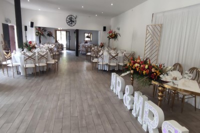Assiette de crevettes grillées servies avec légumes et herbes fraîches, accompagnée de plats en arrière-plan.