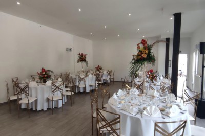 Assiette de crevettes grillées servies avec légumes et herbes fraîches, accompagnée de plats en arrière-plan.