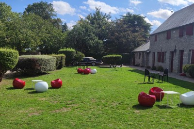 Chambre lumineuse avec deux lits simples, un lit double, un berceau et une décoration murale à motifs géométriques.