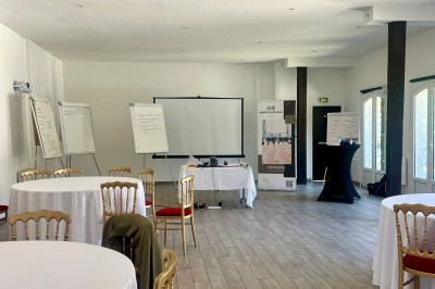 Chambre lumineuse avec deux lits simples, un lit double, un berceau et une décoration murale à motifs géométriques.