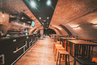 Miniature Location salle Le Mans (Sarthe) - Levrette Café le Mans #2 Salle de bar avec tables hautes, chaises colorées, éclairage chaleureux et décorations murales.