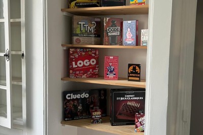 Chambre avec lits superposés en bois, poutres apparentes au plafond et sol en tomettes anciennes.