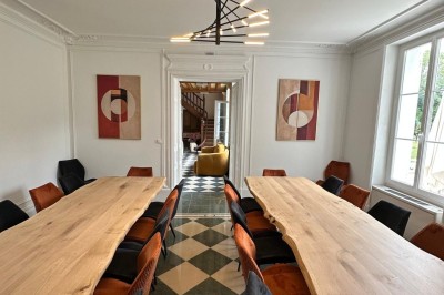 Chambre avec lits superposés en bois, poutres apparentes au plafond et sol en tomettes anciennes.