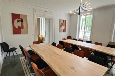 Chambre avec lits superposés en bois, poutres apparentes au plafond et sol en tomettes anciennes.