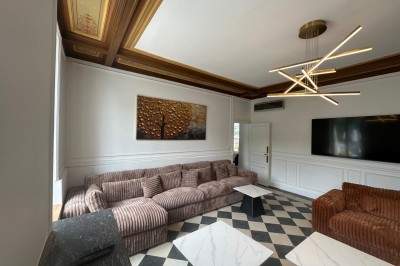 Chambre avec lits superposés en bois, poutres apparentes au plafond et sol en tomettes anciennes.