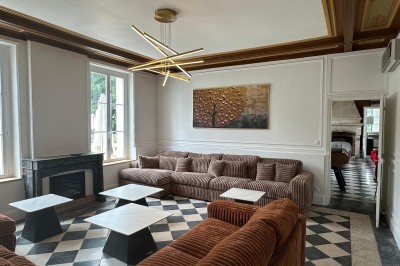 Chambre avec lits superposés en bois, poutres apparentes au plafond et sol en tomettes anciennes.