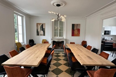 Chambre avec lits superposés en bois, poutres apparentes au plafond et sol en tomettes anciennes.