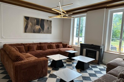 Chambre avec lits superposés en bois, poutres apparentes au plafond et sol en tomettes anciennes.