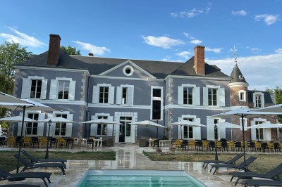 Chambre avec lits superposés en bois, poutres apparentes au plafond et sol en tomettes anciennes.