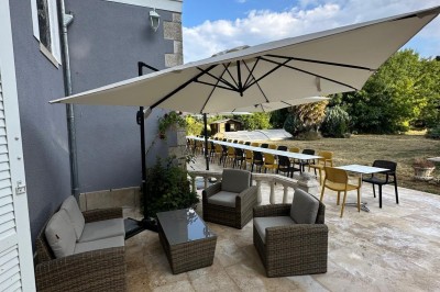 Chambre avec lits superposés en bois, poutres apparentes au plafond et sol en tomettes anciennes.