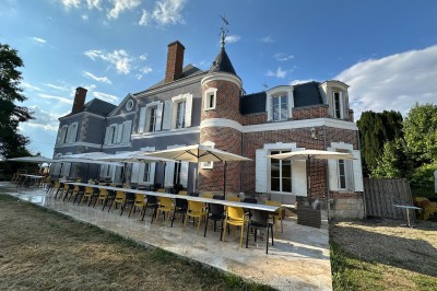 Chambre avec lits superposés en bois, poutres apparentes au plafond et sol en tomettes anciennes.