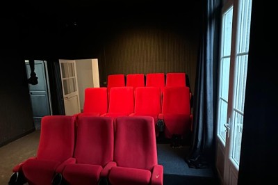 Chambre avec lits superposés en bois, poutres apparentes au plafond et sol en tomettes anciennes.