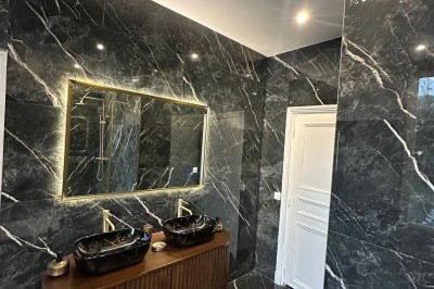 Chambre avec lits superposés en bois, poutres apparentes au plafond et sol en tomettes anciennes.