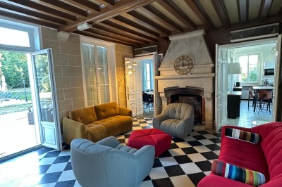 Chambre avec lits superposés en bois, poutres apparentes au plafond et sol en tomettes anciennes.