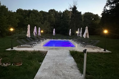 Chambre avec lits superposés en bois, poutres apparentes au plafond et sol en tomettes anciennes.