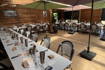 Miniature Location salle Bavent (Calvados) - Domaine des Rouges Terres #4 Allée pavée bordée de verdure, avec un mini-golf et des bâtiments en bois sous un ciel dégagé.