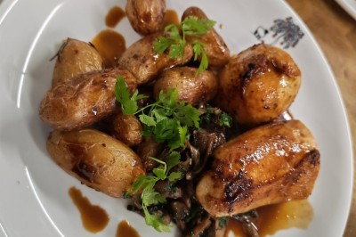 Assiette de dessert composée de mousse, pommes, caramel et crumble, présentée avec soin sur une table sombre.