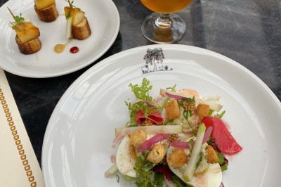 Assiette de dessert composée de mousse, pommes, caramel et crumble, présentée avec soin sur une table sombre.