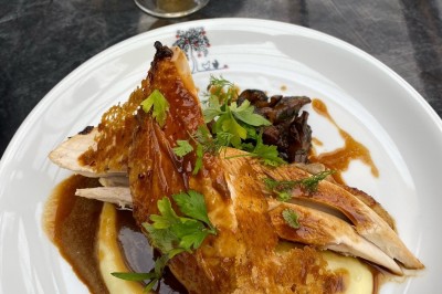 Assiette de dessert composée de mousse, pommes, caramel et crumble, présentée avec soin sur une table sombre.