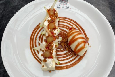 Miniature Location salle Bavent (Calvados) - Domaine des Rouges Terres #15 Assiette de dessert composée de mousse, pommes, caramel et crumble, présentée avec soin sur une table sombre.