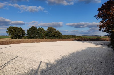 Miniature Location salle Lescherolles (Seine-et-Marne) - Le Domaine du Château Oublié #22 Champ recouvert de matière blanche sous un ciel bleu parsemé de nuages, bordé d'arbres et de haies.