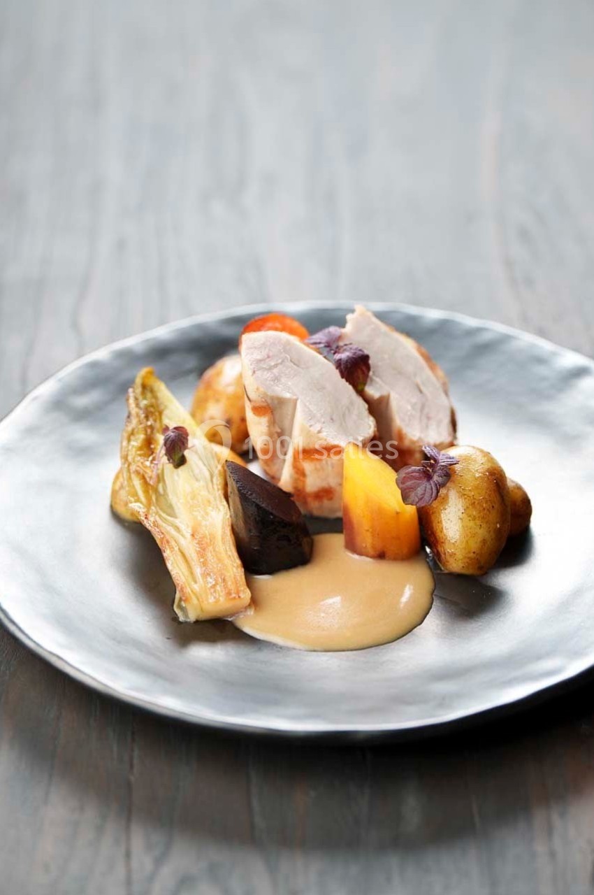 Assiette gastronomique avec volaille, légumes racines, endive braisée, pommes de terre et sauce crémeuse.