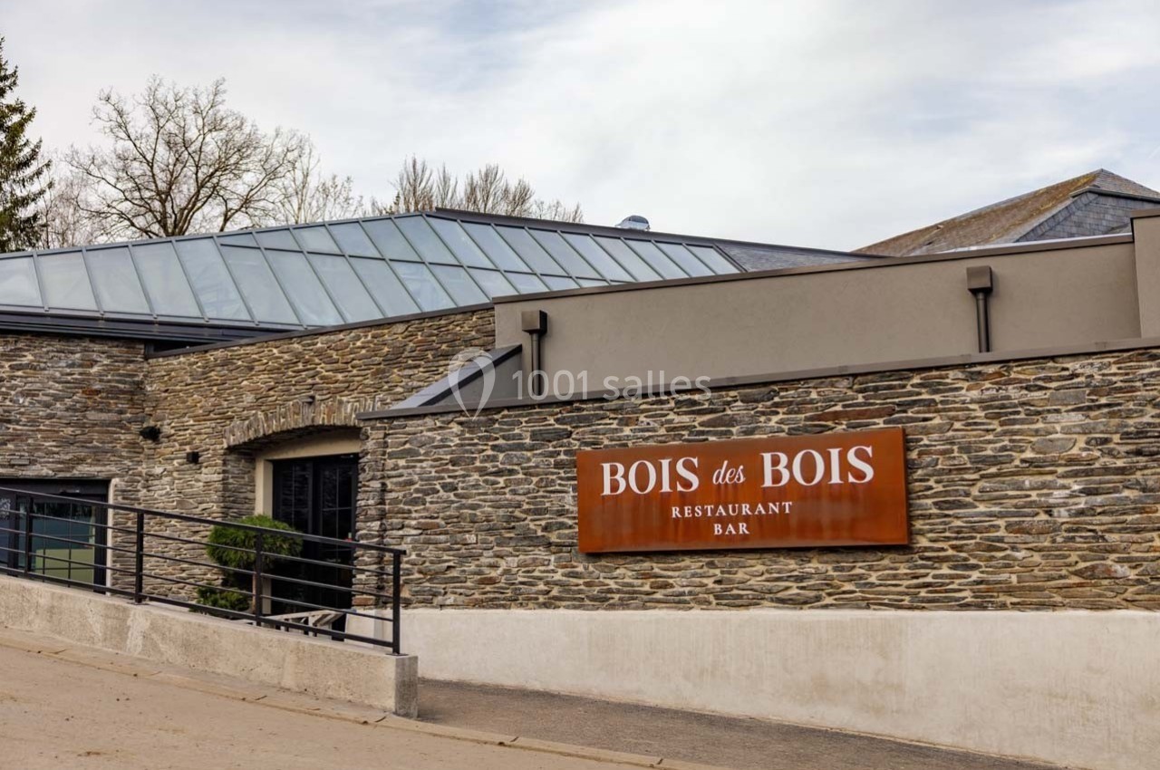 Façade en pierre d'un restaurant avec une enseigne ’Bois des Bois’ et un toit en verre moderne.