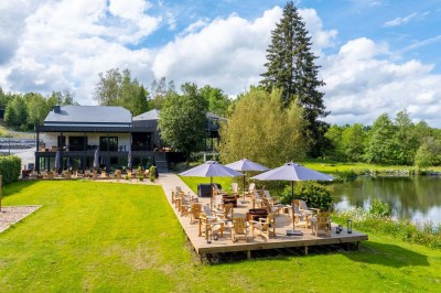 Miniature Location salle Neufchâteau (Luxembourg) - Landal Hillview Resort Grandvoir #2 Banc en bois face à un étang entouré de végétation et d'arbres sous un ciel partiellement nuageux.