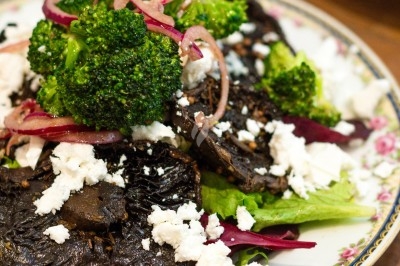 Assiette de magret de canard tranché sur purée de patates douces, garni de persil et accompagné d'une sauce.