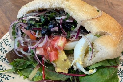 Assiette de magret de canard tranché sur purée de patates douces, garni de persil et accompagné d'une sauce.