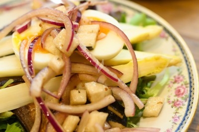 Assiette de magret de canard tranché sur purée de patates douces, garni de persil et accompagné d'une sauce.