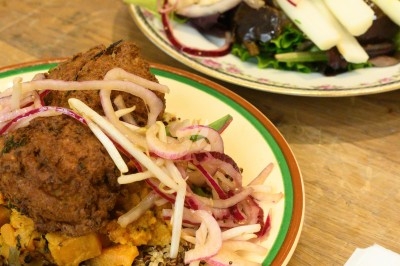 Assiette de magret de canard tranché sur purée de patates douces, garni de persil et accompagné d'une sauce.