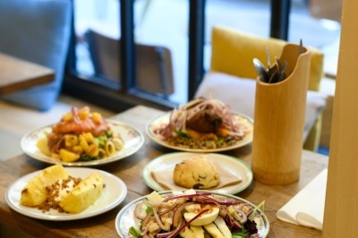 Assiette de magret de canard tranché sur purée de patates douces, garni de persil et accompagné d'une sauce.