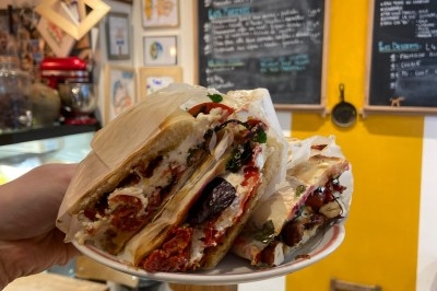 Assiette de magret de canard tranché sur purée de patates douces, garni de persil et accompagné d'une sauce.