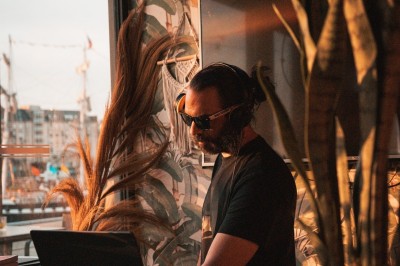 Un homme prépare un plat avec soin dans un cadre lumineux, entouré de bols et d'ingrédients sur une table.