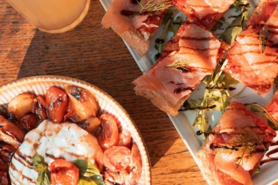 Un homme prépare un plat avec soin dans un cadre lumineux, entouré de bols et d'ingrédients sur une table.