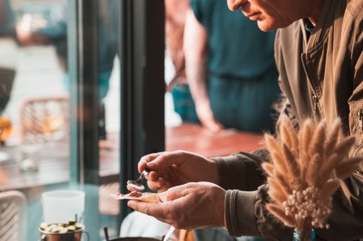 Un homme prépare un plat avec soin dans un cadre lumineux, entouré de bols et d'ingrédients sur une table.