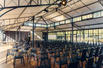 Trois femmes souriantes lisent des magazines allongées sur un lit dans une chambre lumineuse.