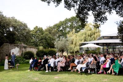 Trois femmes souriantes lisent des magazines allongées sur un lit dans une chambre lumineuse.