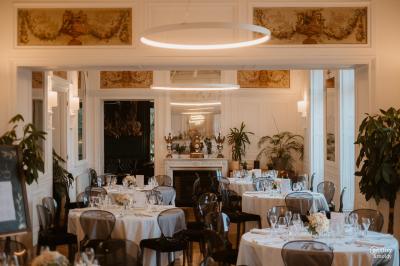 Trois femmes souriantes lisent des magazines allongées sur un lit dans une chambre lumineuse.