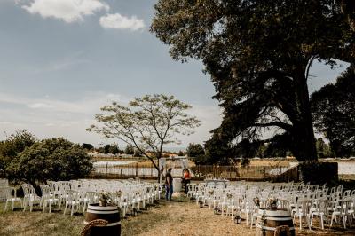 Trois femmes souriantes lisent des magazines allongées sur un lit dans une chambre lumineuse.