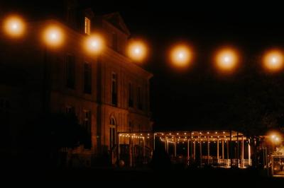 Trois femmes souriantes lisent des magazines allongées sur un lit dans une chambre lumineuse.