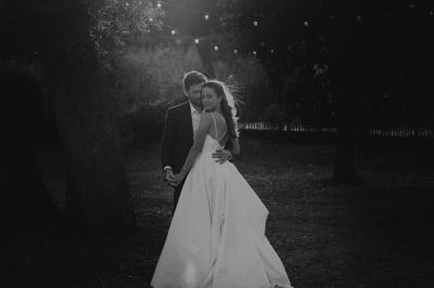 Trois femmes souriantes lisent des magazines allongées sur un lit dans une chambre lumineuse.