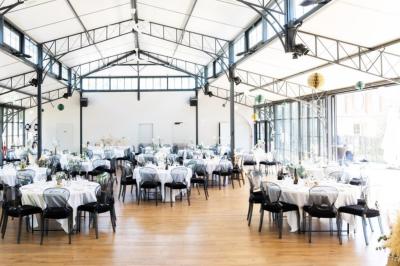Trois femmes souriantes lisent des magazines allongées sur un lit dans une chambre lumineuse.