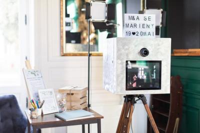 Trois femmes souriantes lisent des magazines allongées sur un lit dans une chambre lumineuse.