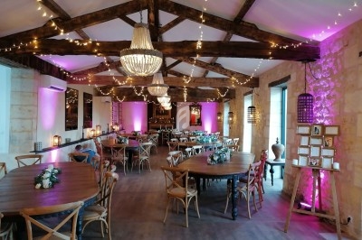 Personnes dansant dans une salle éclairée par des lumières colorées, ambiance festive en soirée.