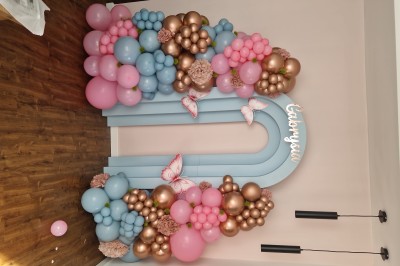 Miniature La Magie des Ballons #7 Arc décoratif en ballons roses, bleus et dorés avec papillons, installé dans une pièce au sol en bois.