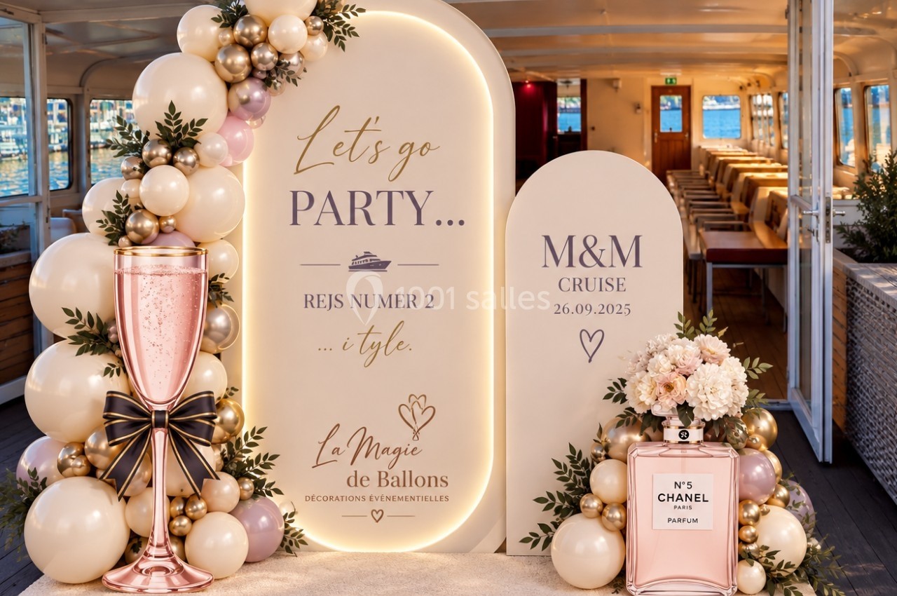 Décoration festive avec ballons, fleurs et panneaux lumineux sur un bateau, évoquant une croisière événementielle.