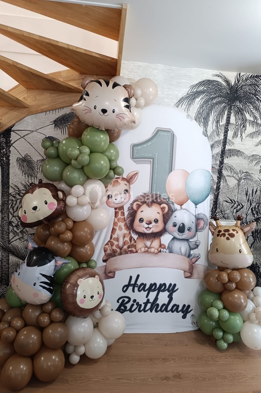 Décoration d'anniversaire avec ballons en forme d'animaux et un panneau ’Happy Birthday’ avec le chiffre 1.